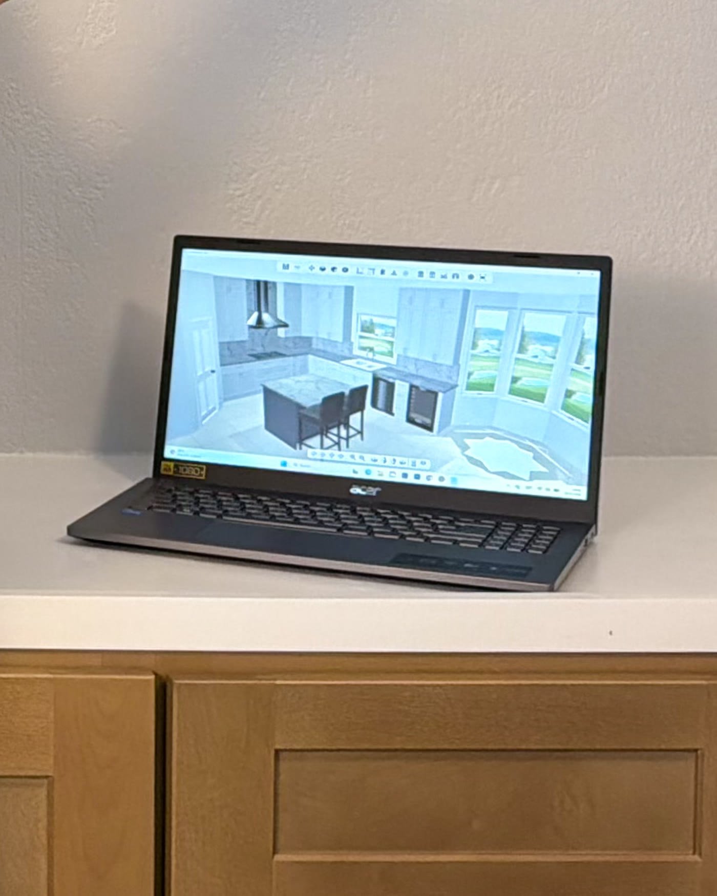 A laptop on the counter showing the 3D model of a kitchen before it is built